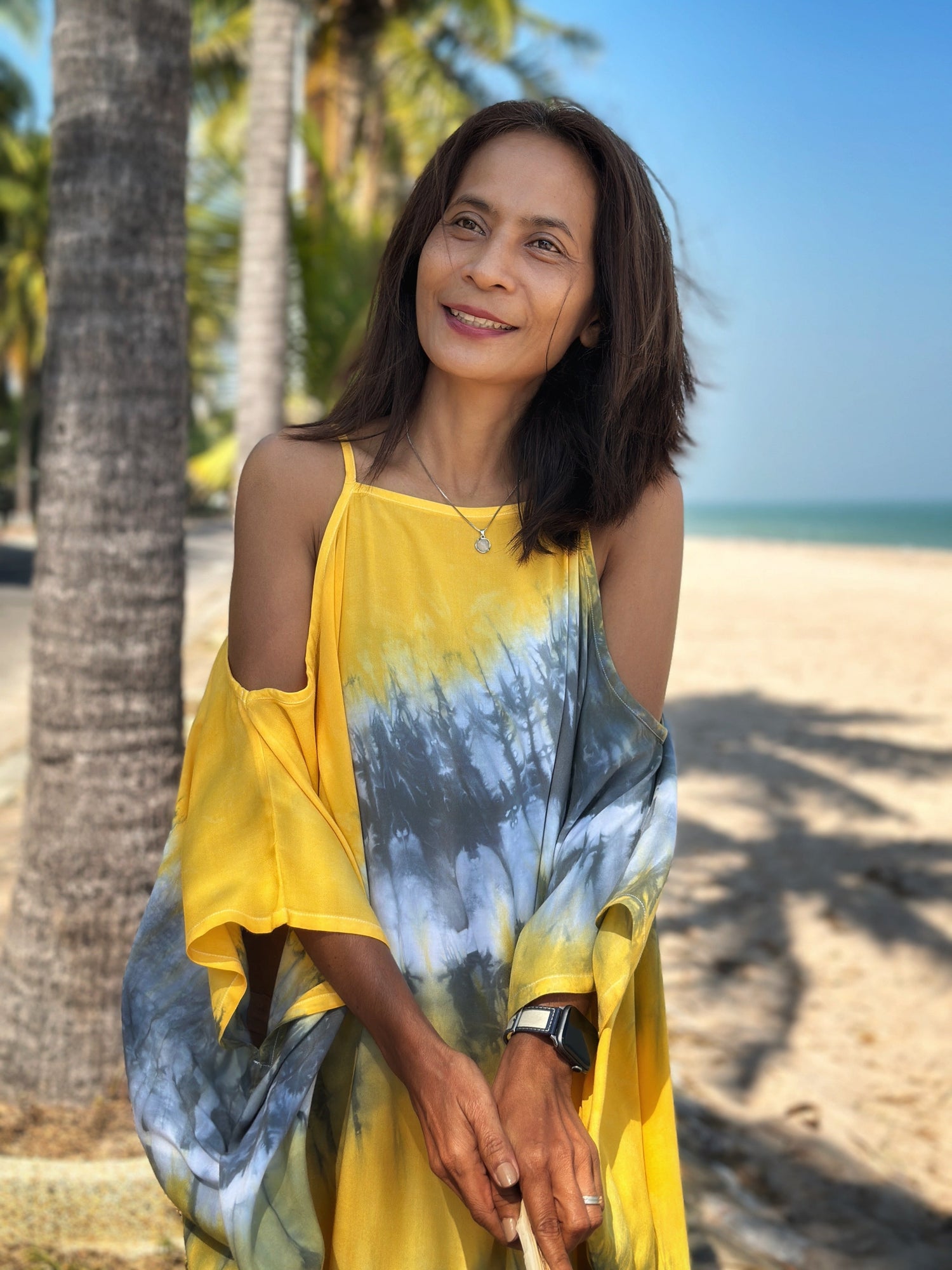 Girl walking on the beach wearing a shibori tie dye summer dress