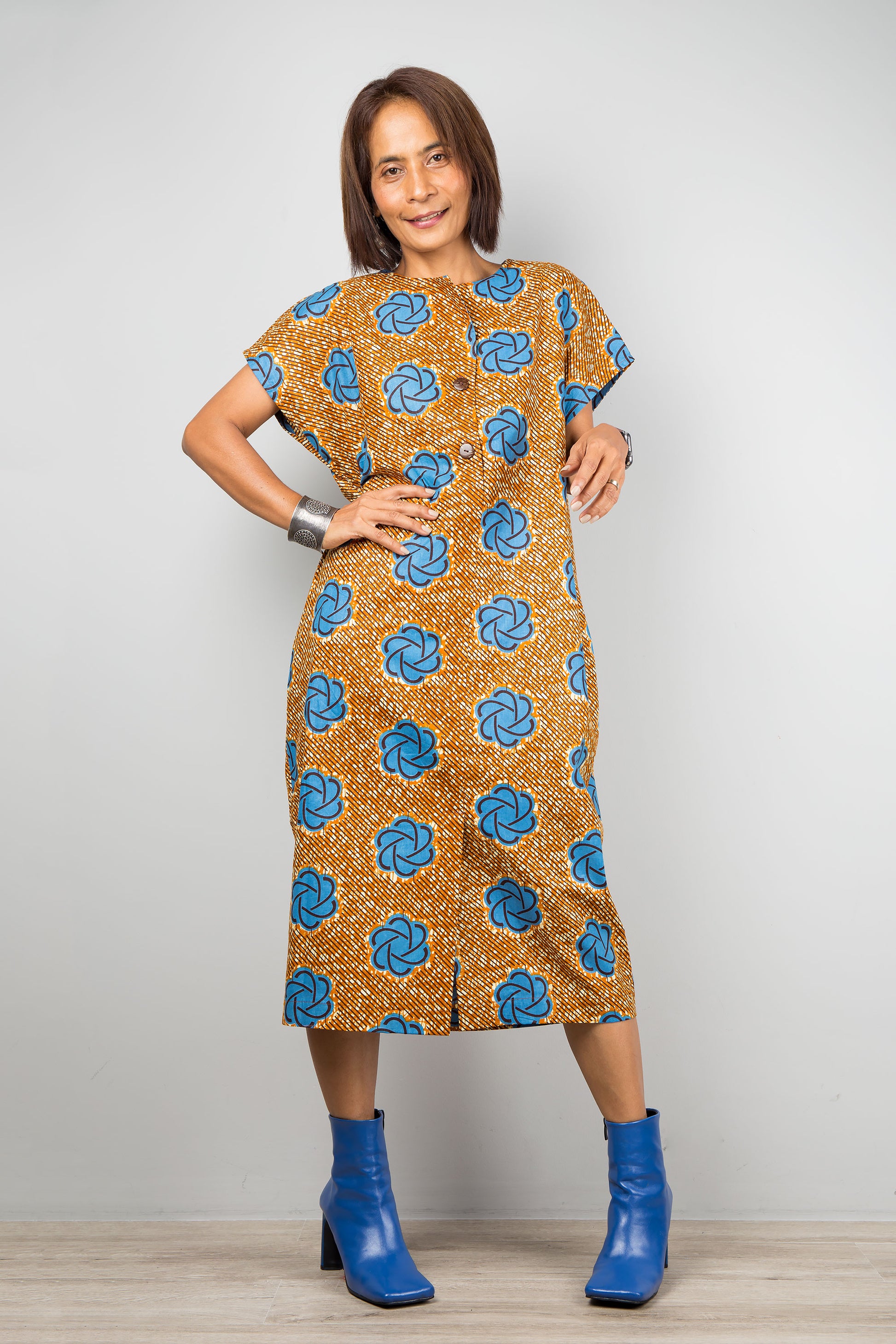 Mid length cotton ankara dress with blue print. Front view of a dress with cap sleeves and african print, coconut buttons
