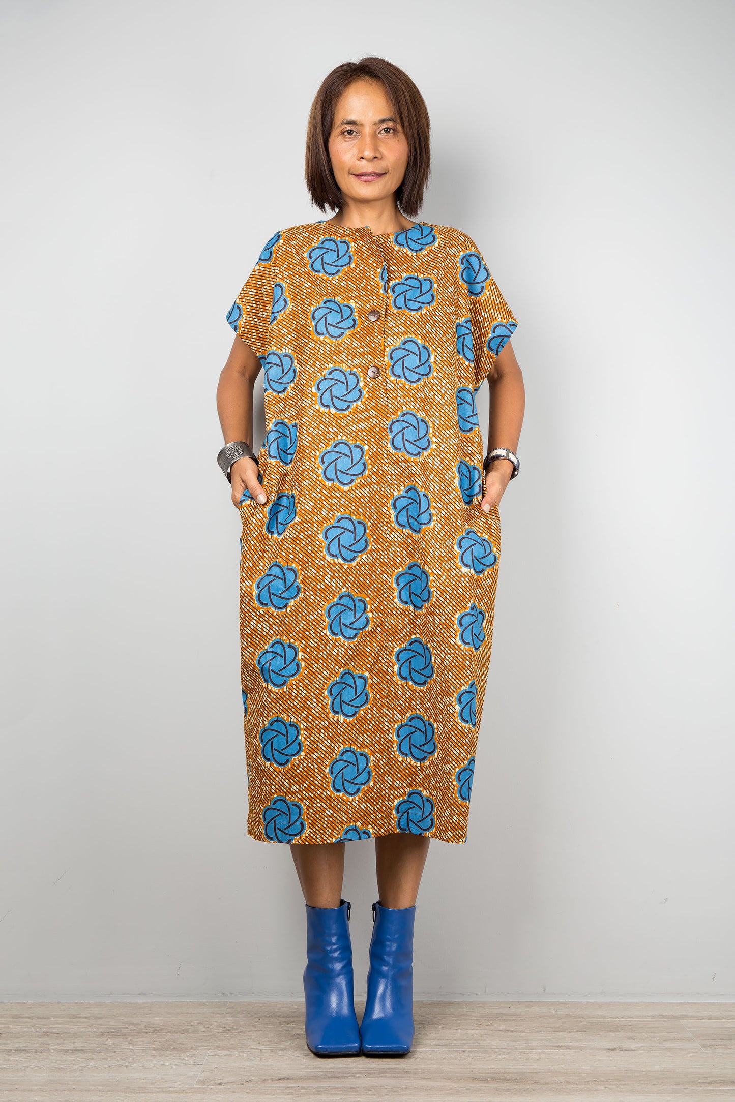 Mid length cotton ankara dress with blue print. Front view of a dress with cap sleeves and african print, inseam side pockets