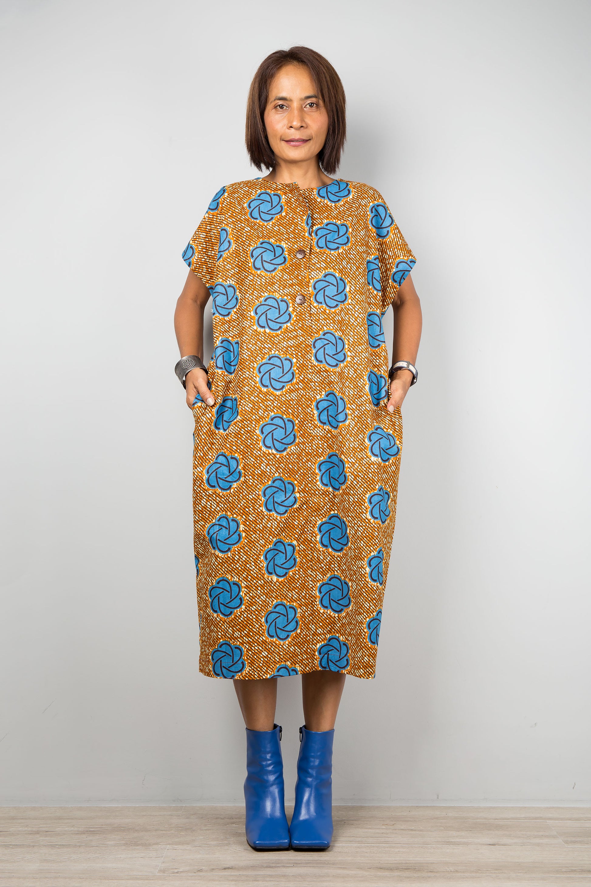 Mid length cotton ankara dress with blue print. Front view of a dress with cap sleeves and african print, inseam side pockets