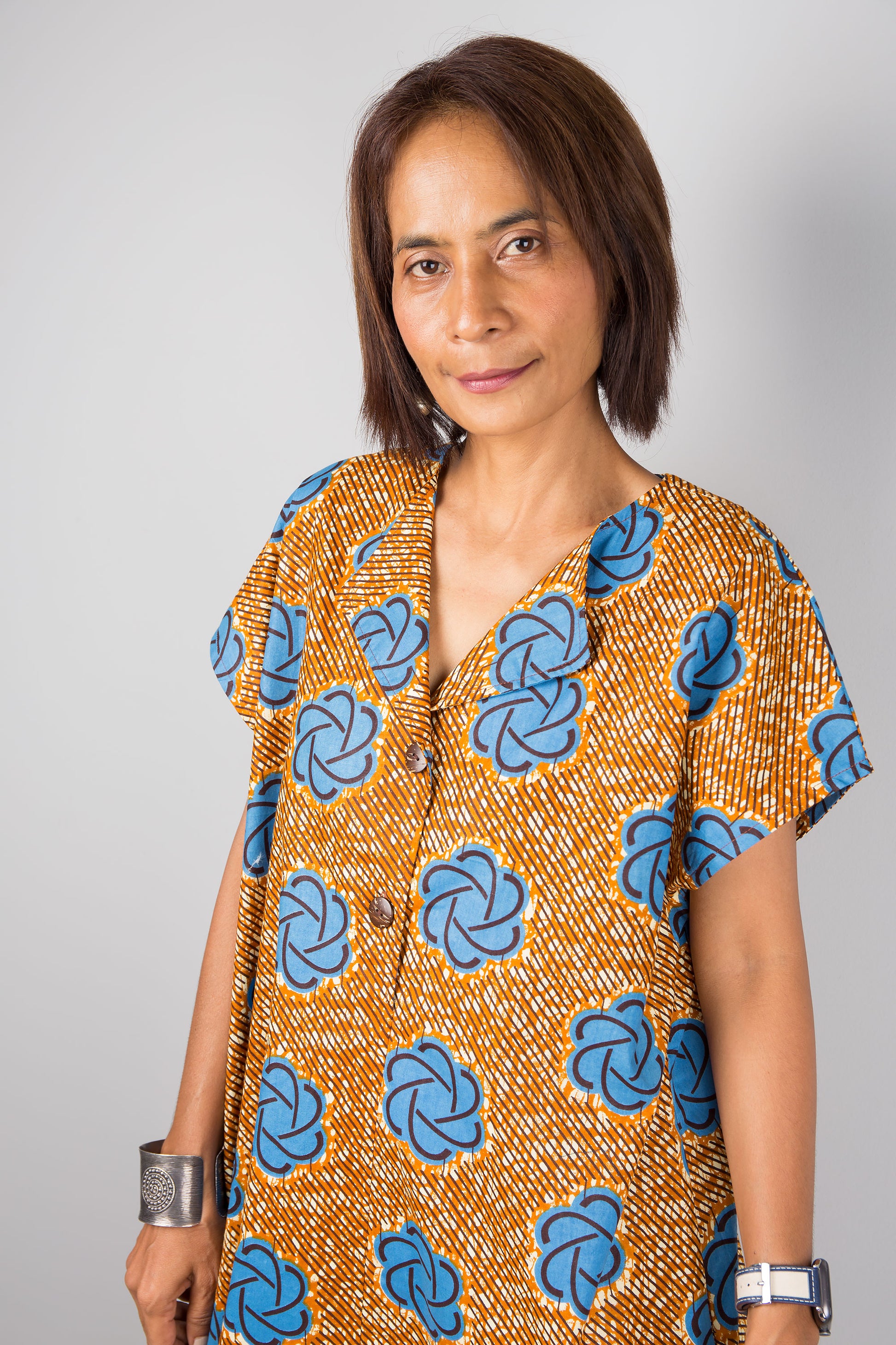 Mid length cotton ankara dress with blue print. Close up view of a dress with cap sleeves and african print