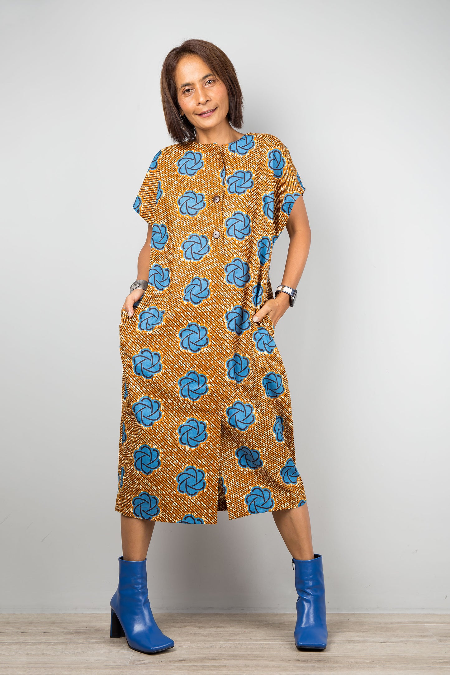 Mid length cotton ankara dress with blue print. Front view of a dress with cap sleeves and african print, bottom split
