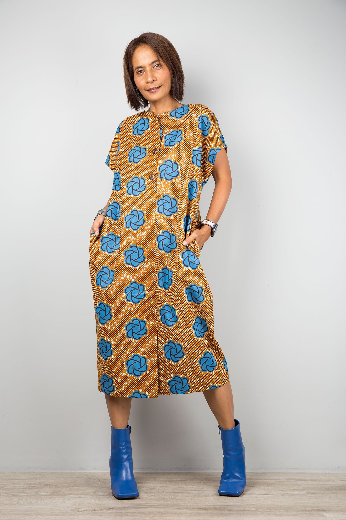 Mid length cotton ankara dress with blue print. Front view of a dress with cap sleeves and african print, 2 inseam pockets
