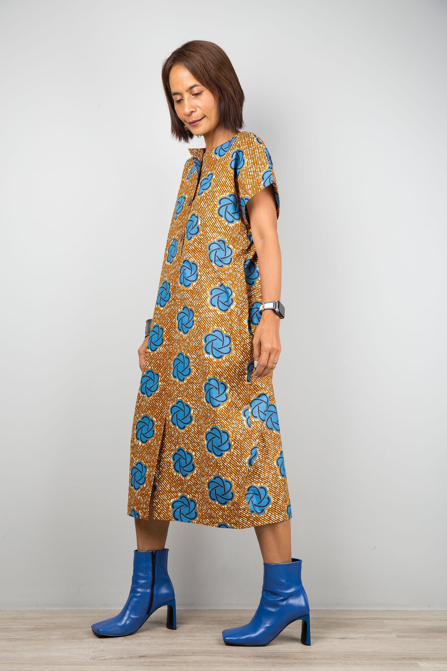 Mid length cotton ankara dress with blue print. Side view of a dress with cap sleeves and african print
