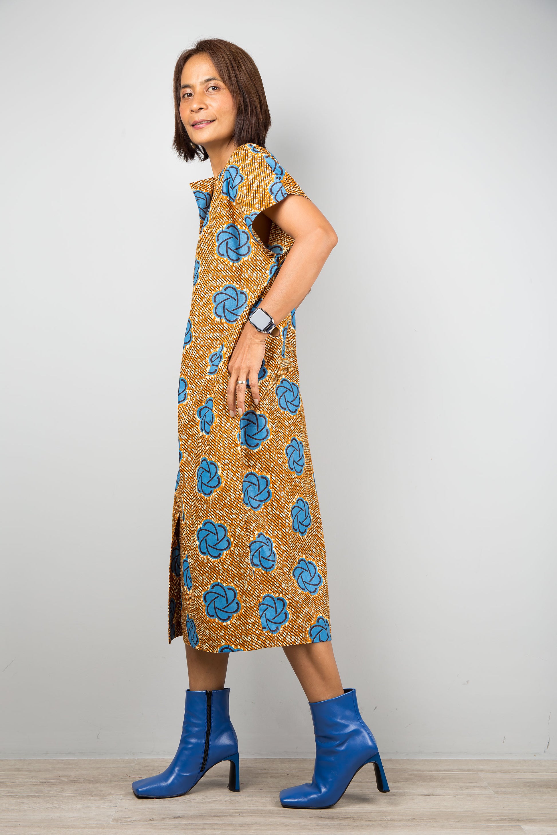 Mid length cotton ankara dress with blue print. Side view of a dress with cap sleeves and african print, bottom split
