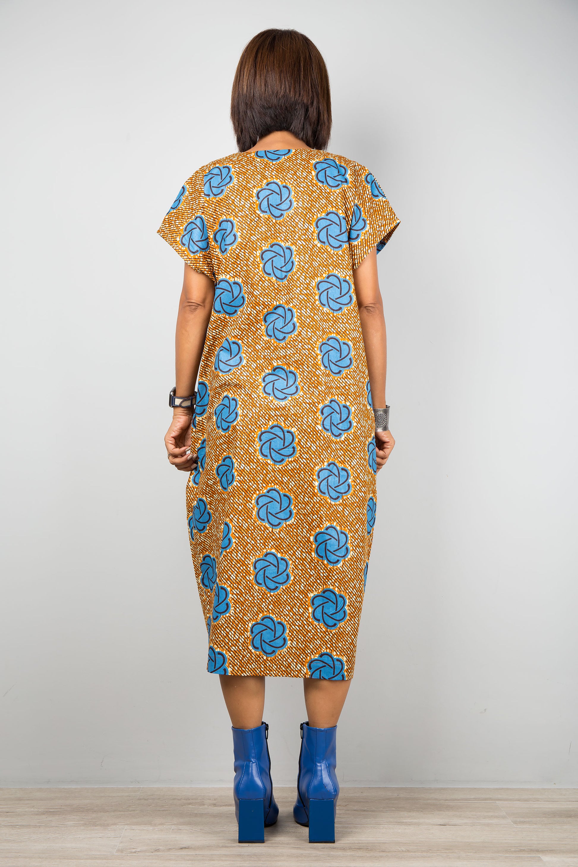 Mid length cotton ankara dress with blue print. Back view of a dress with cap sleeves and african print
