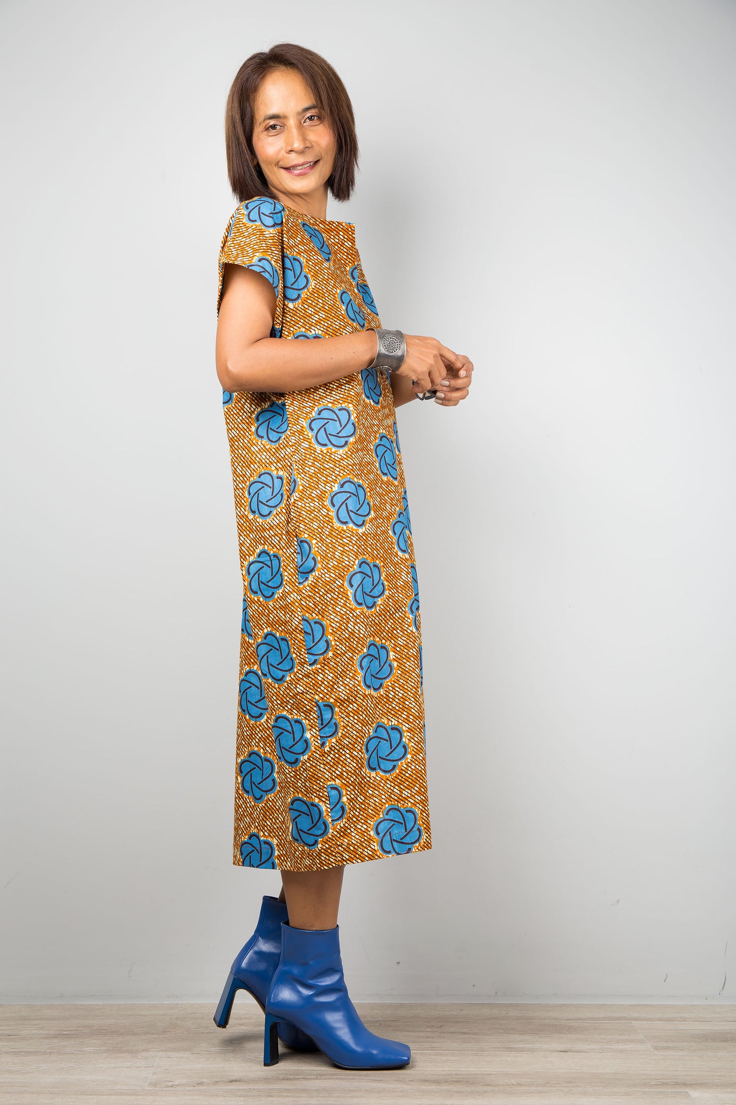 Mid length cotton ankara dress with blue print. Side view of a dress with cap sleeves and african print
