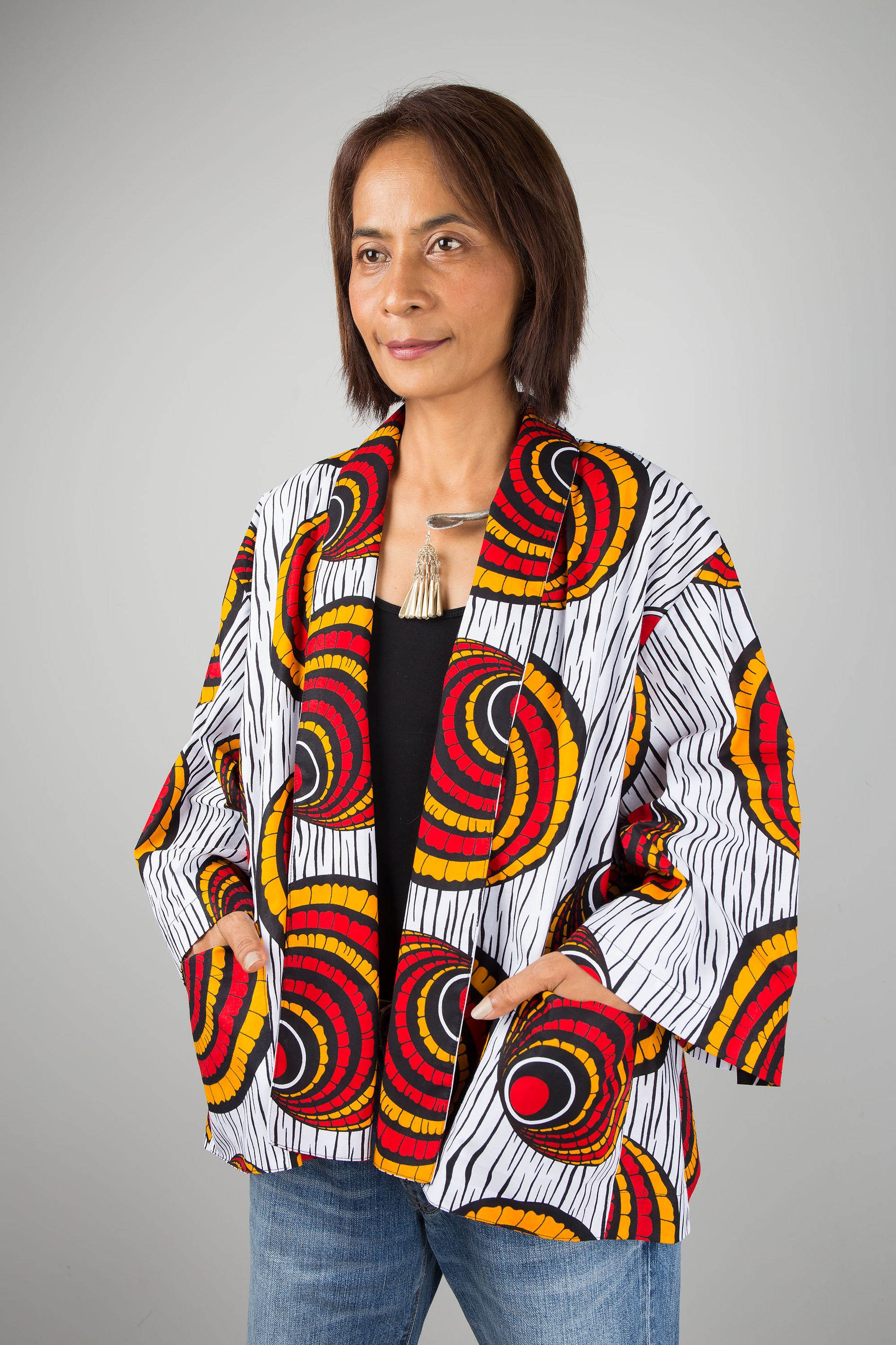 African kimono jacket top.  Short jacket top in ankara fabric.  Hands in pocket view