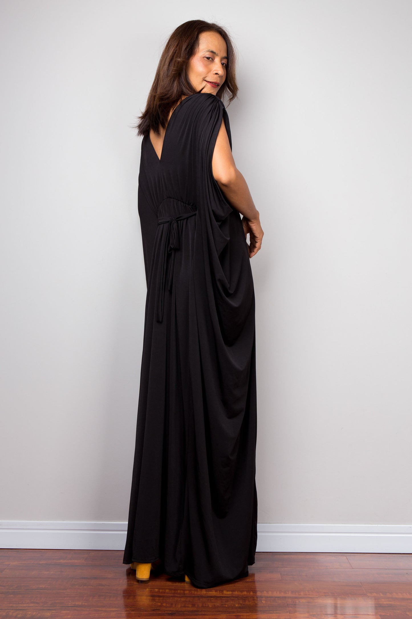 Long black kaftan dress with v neck and braided detail on the waist. Back view