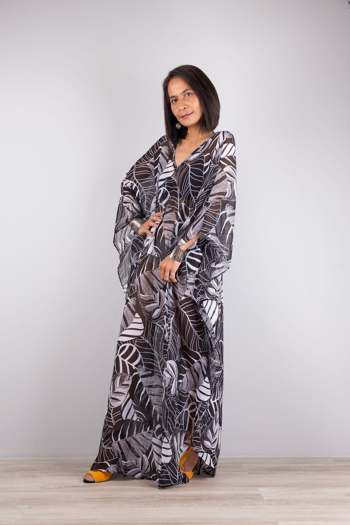 Chiffon kaftan dress in black and white. Loose fit caftan with subtle v neck and batwing sleeves. Side view