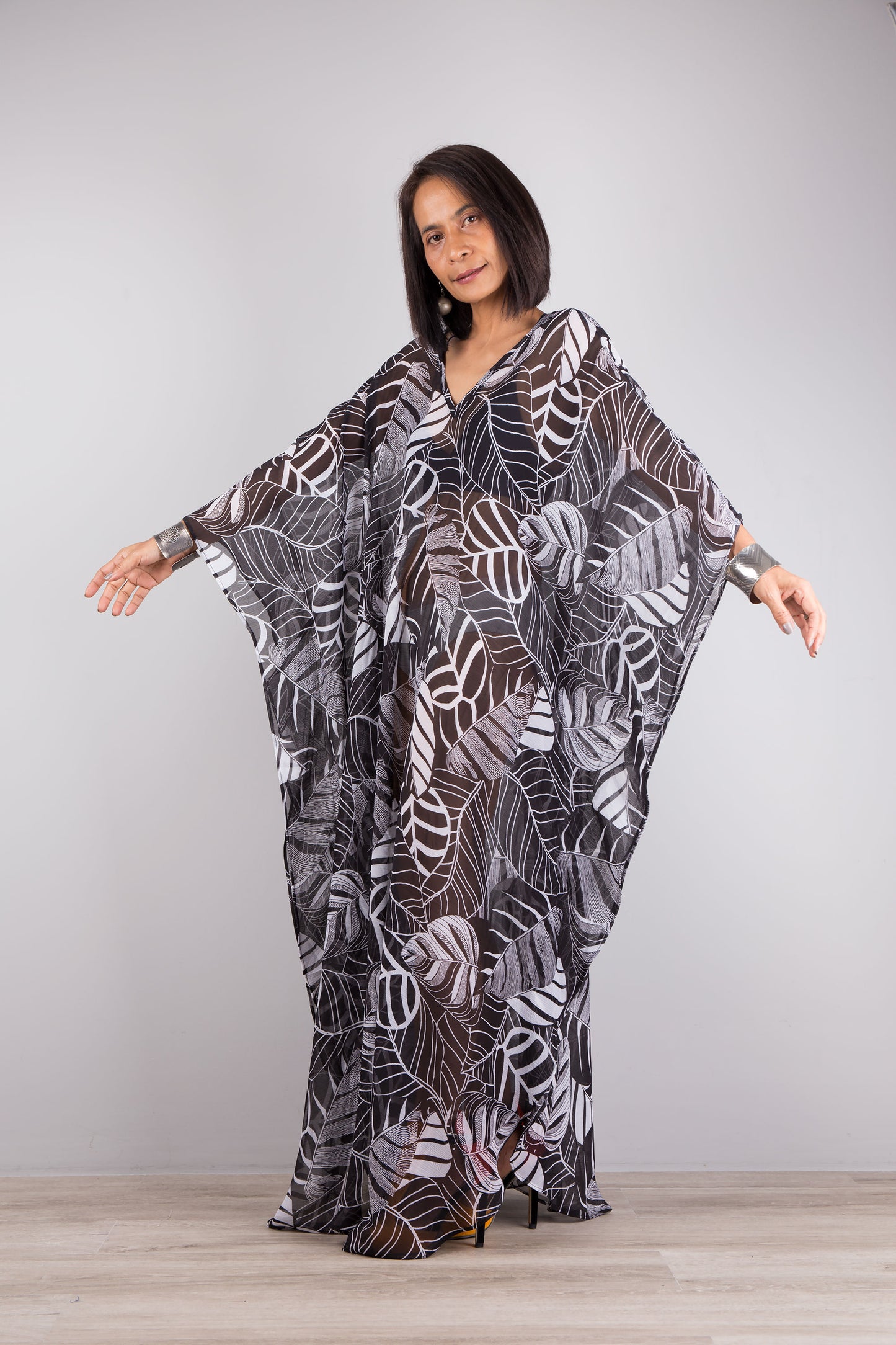 Chiffon kaftan dress in black and white leaf print. Loose fit caftan with subtle v neck and batwing sleeves