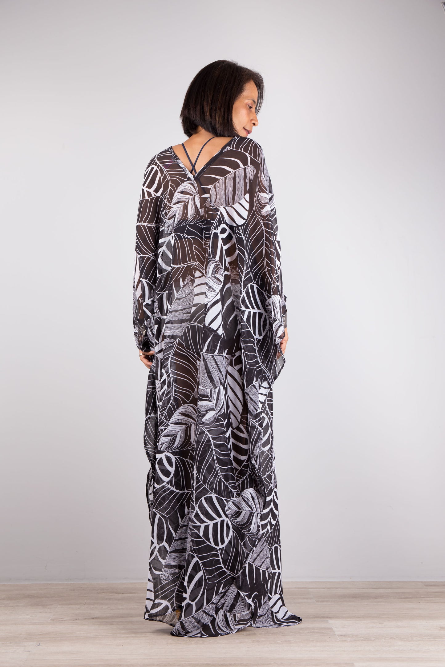 Chiffon kaftan dress in black and white. Loose fit caftan with subtle v neck and batwing sleeves. Back view.