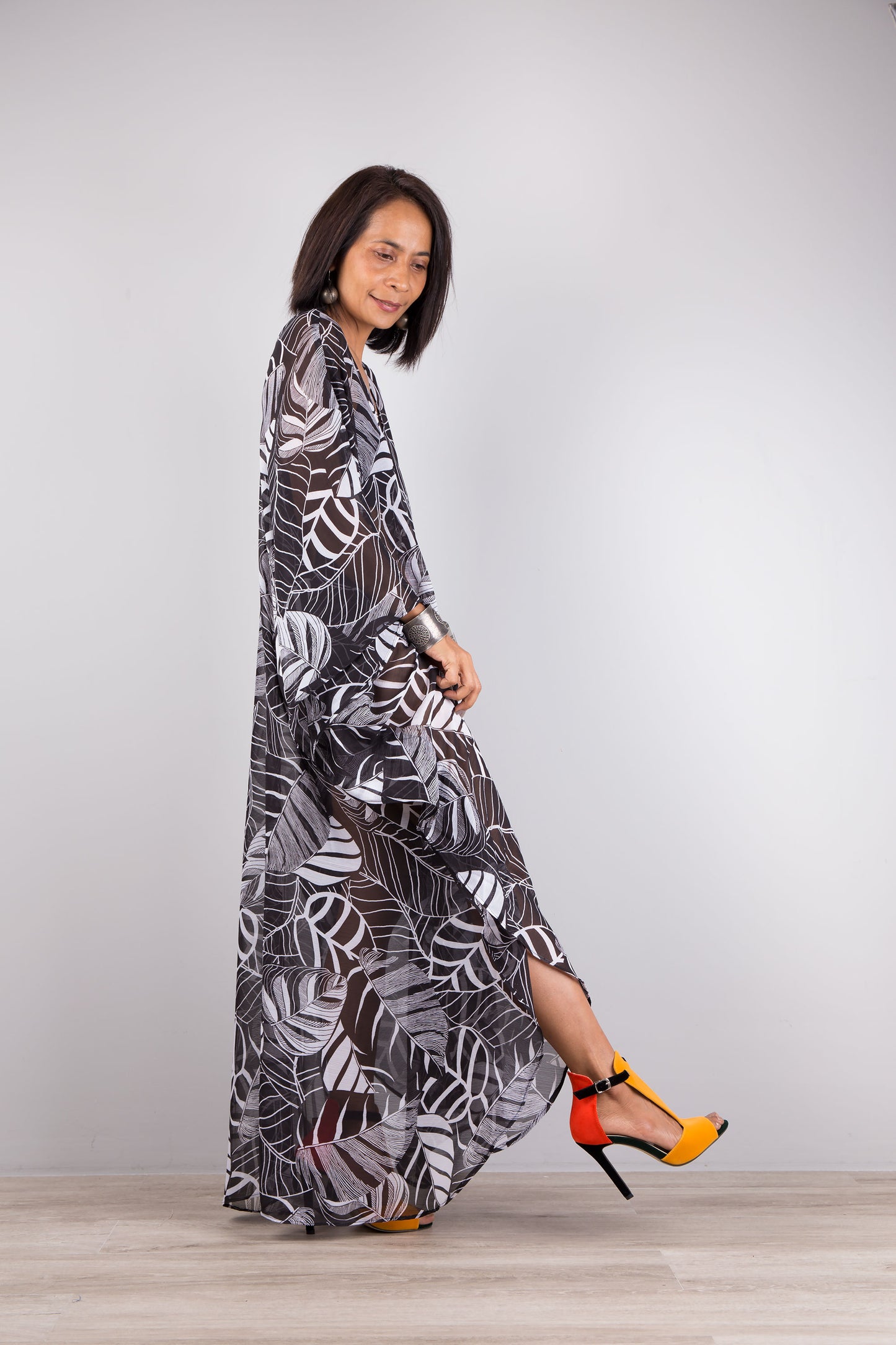 Chiffon kaftan dress in black and white. Loose fit sheer caftan with subtle v neck and batwing sleeves. Side view