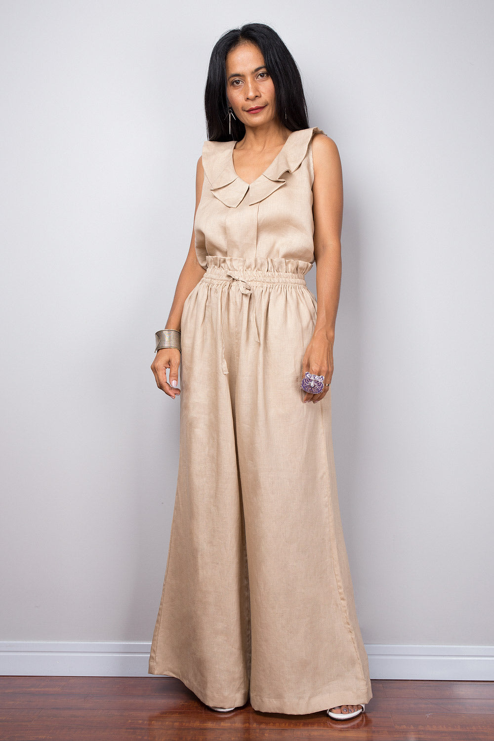 Fashionable beige linen palazzo pants with a high waist, shown on a model, perfect for eco-conscious summer fashion.