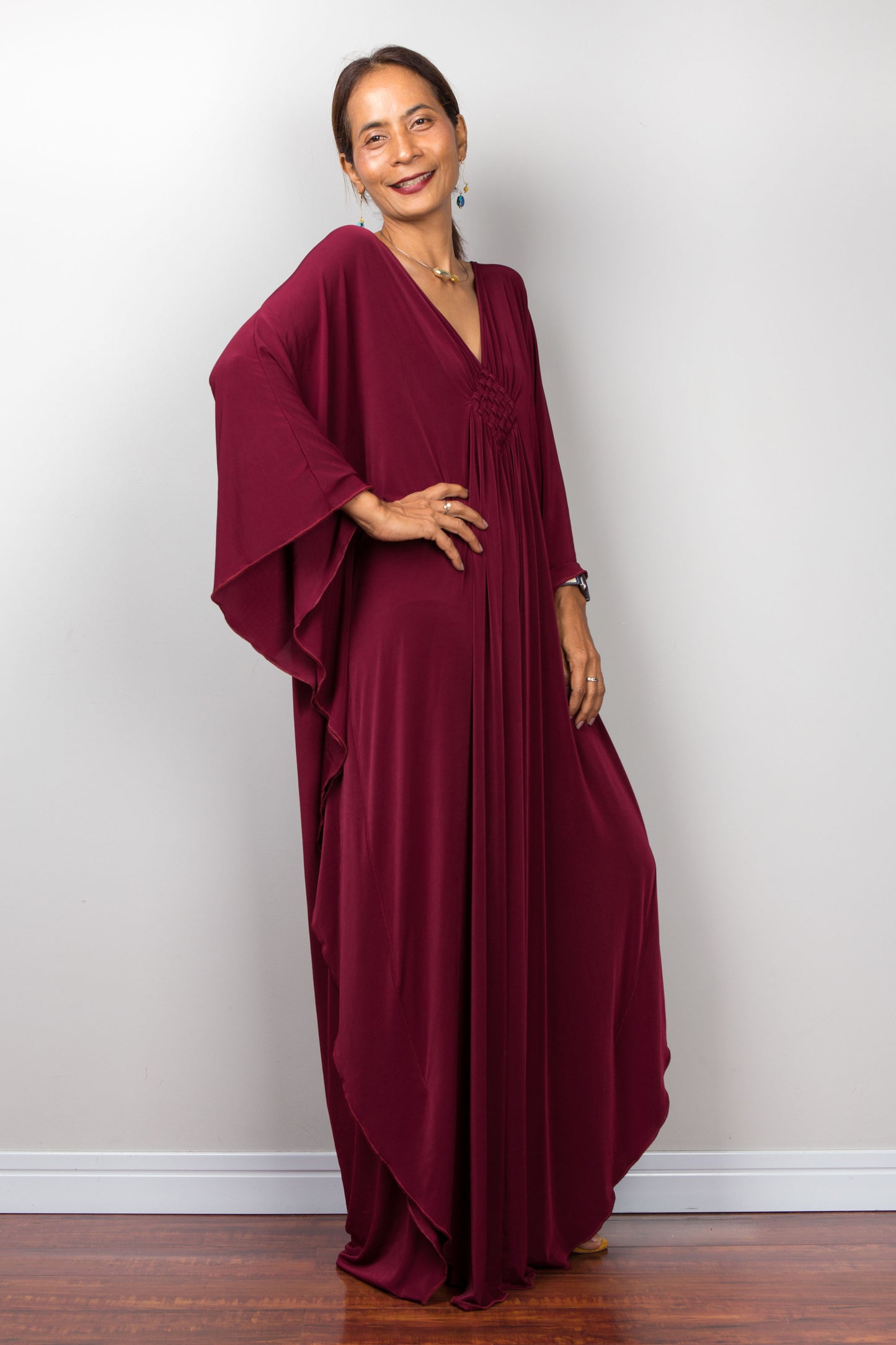 Kaftan dress in a burgundy red.  Plunging neckline and braided diamond shape detail on the chest