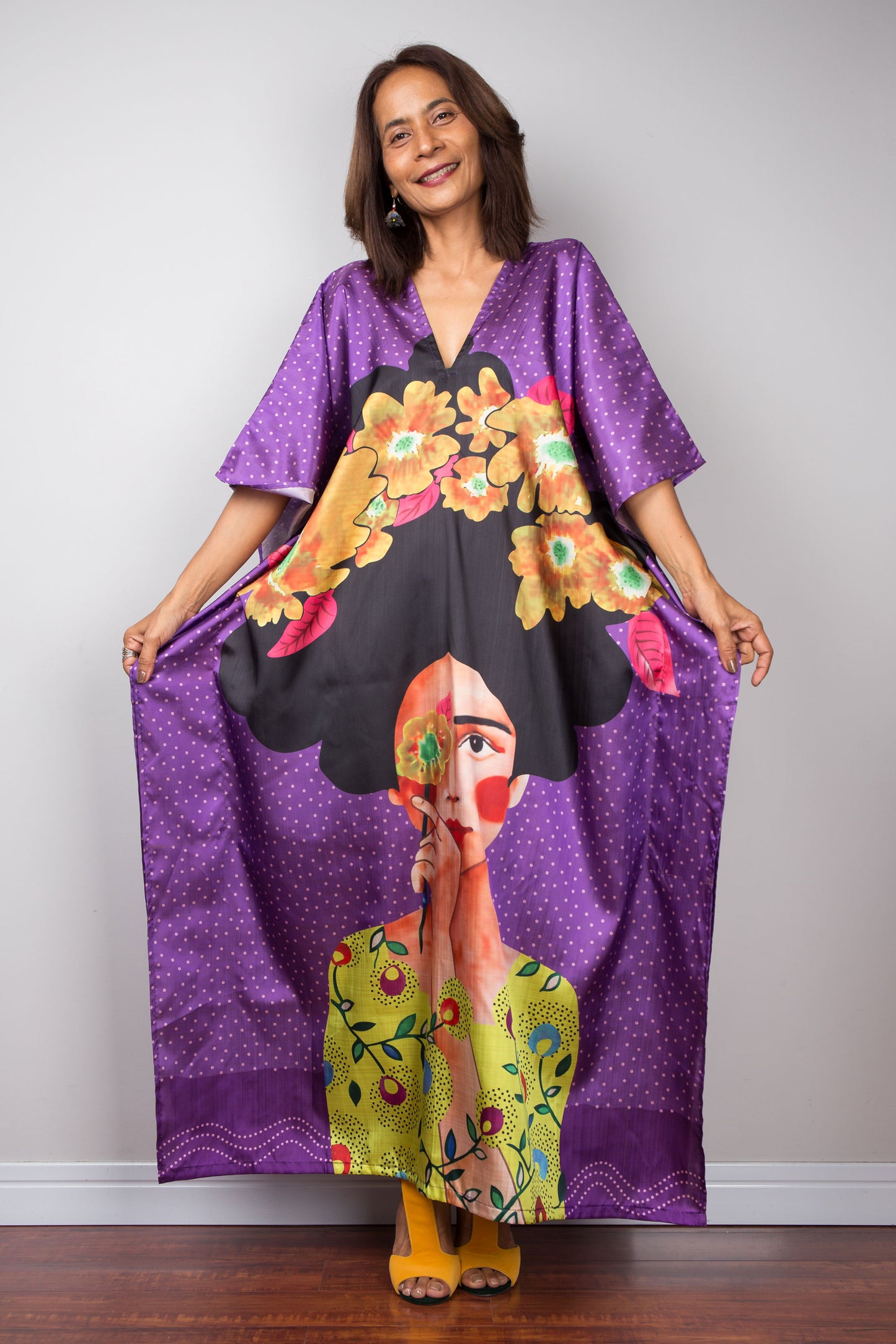 Woman in vibrant silk satin kaftan with large boho print design.