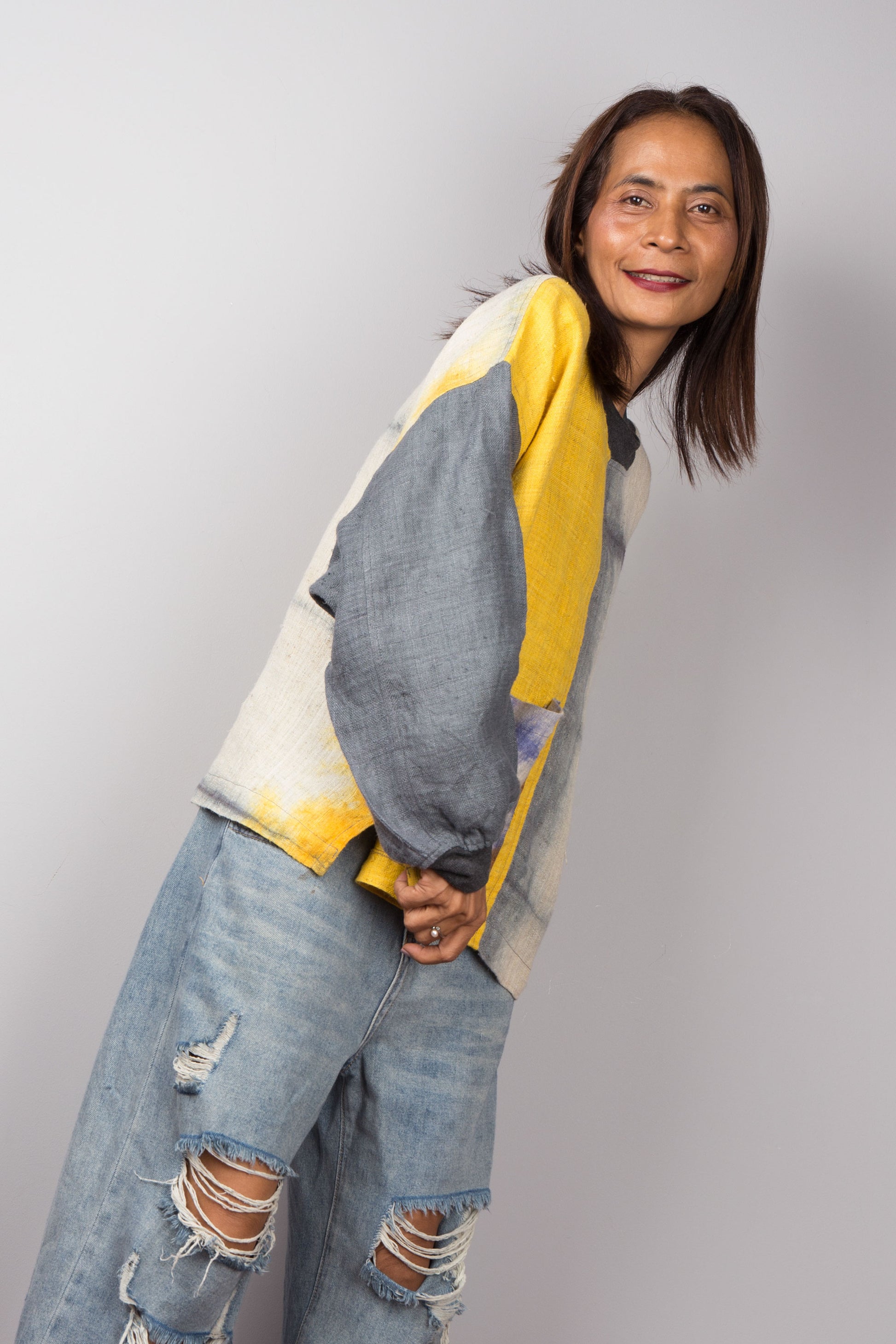 Hemp sweater in yellow and grey with shibori tie dye detail on the front pocket. Long sleeve pullover with crew neck.