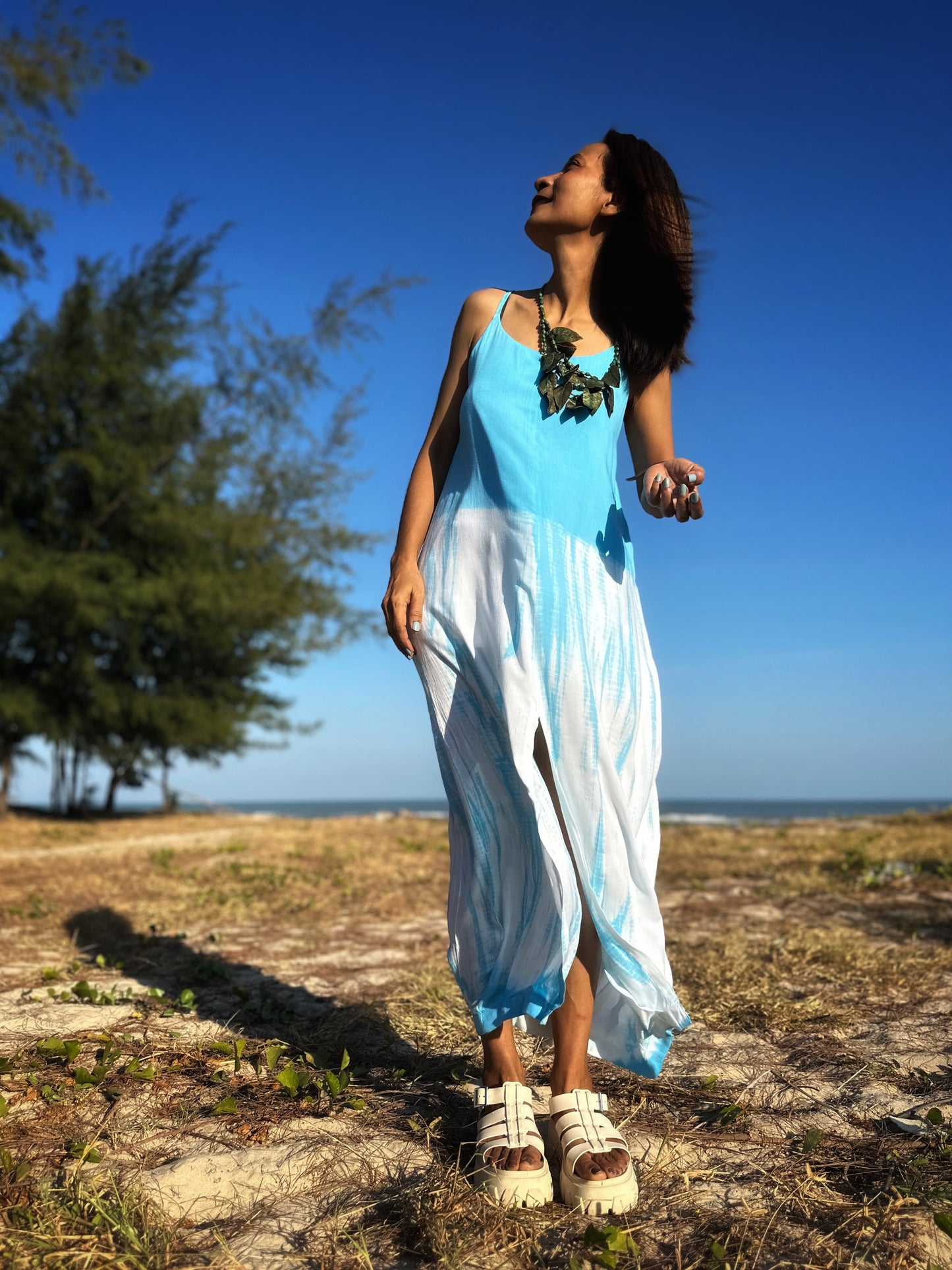 Front view of a light blue shibori tie dye strap dress, revealing the one-size-fits-most fit and the artful dye work.