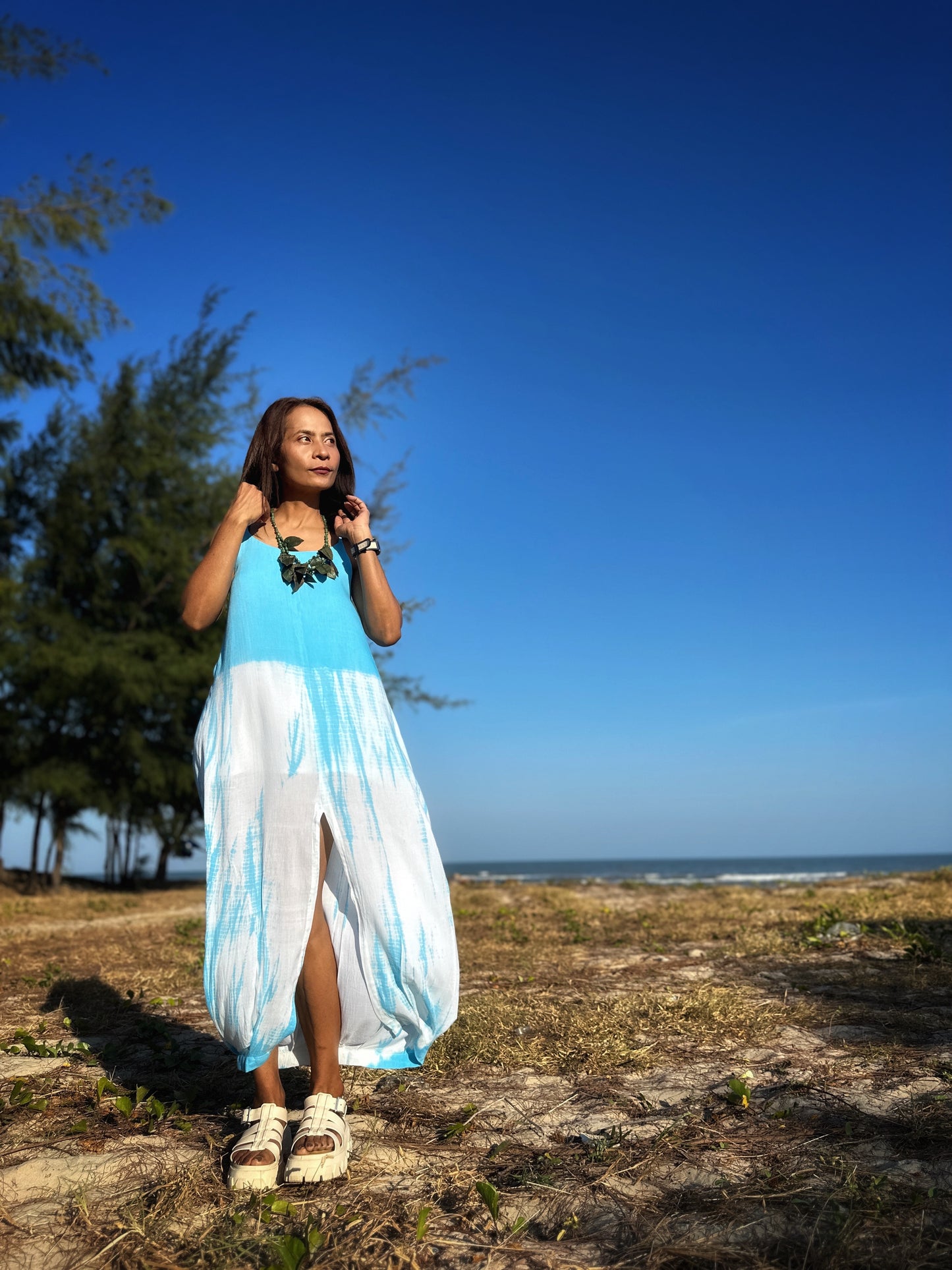 Woman walking in the blue shibori dress with split, illustrating its versatility for both casual and chic occasions