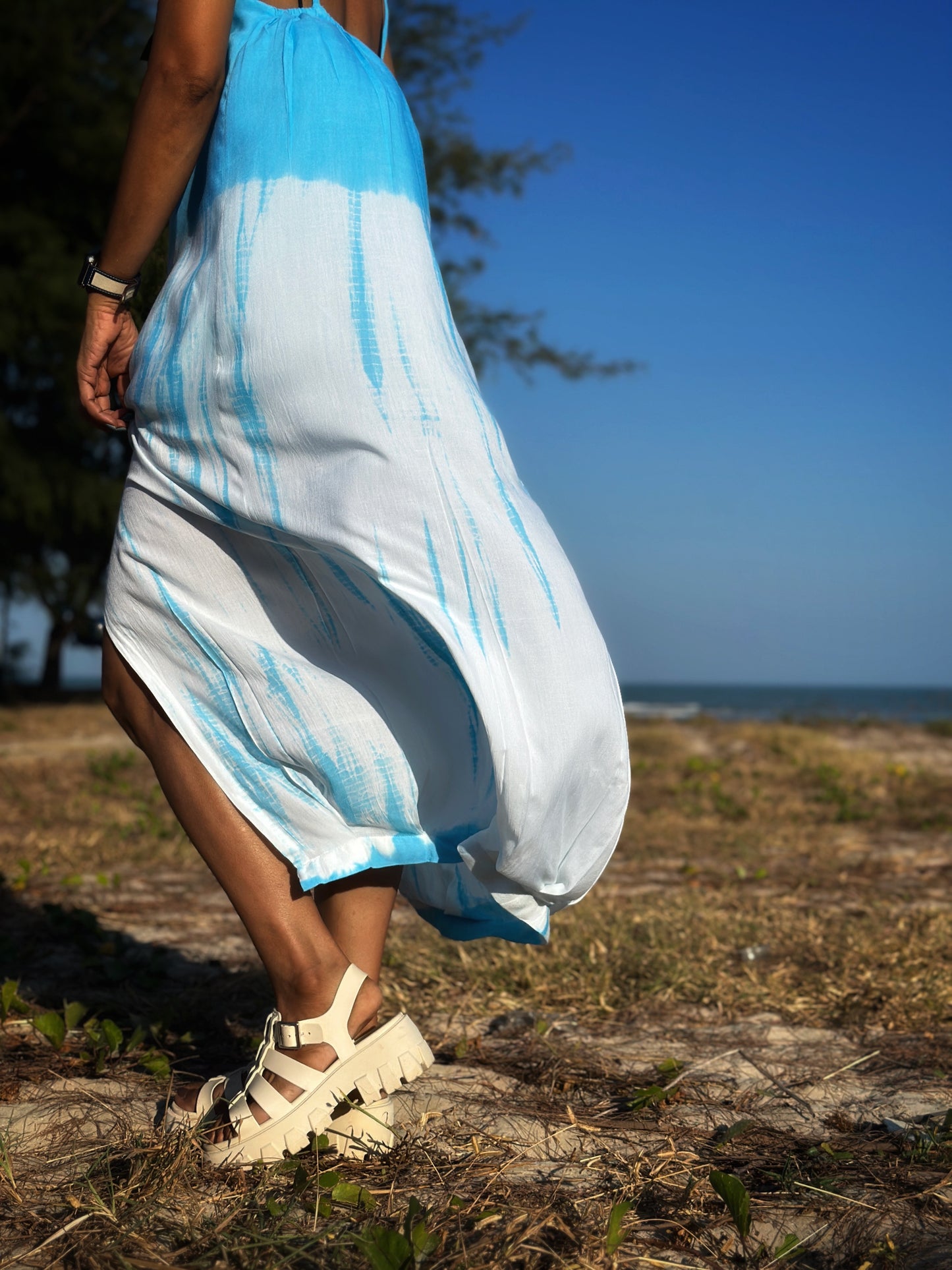 Side view of the light blue tie dye dress, demonstrating the chic split design that adds movement to the outfit.