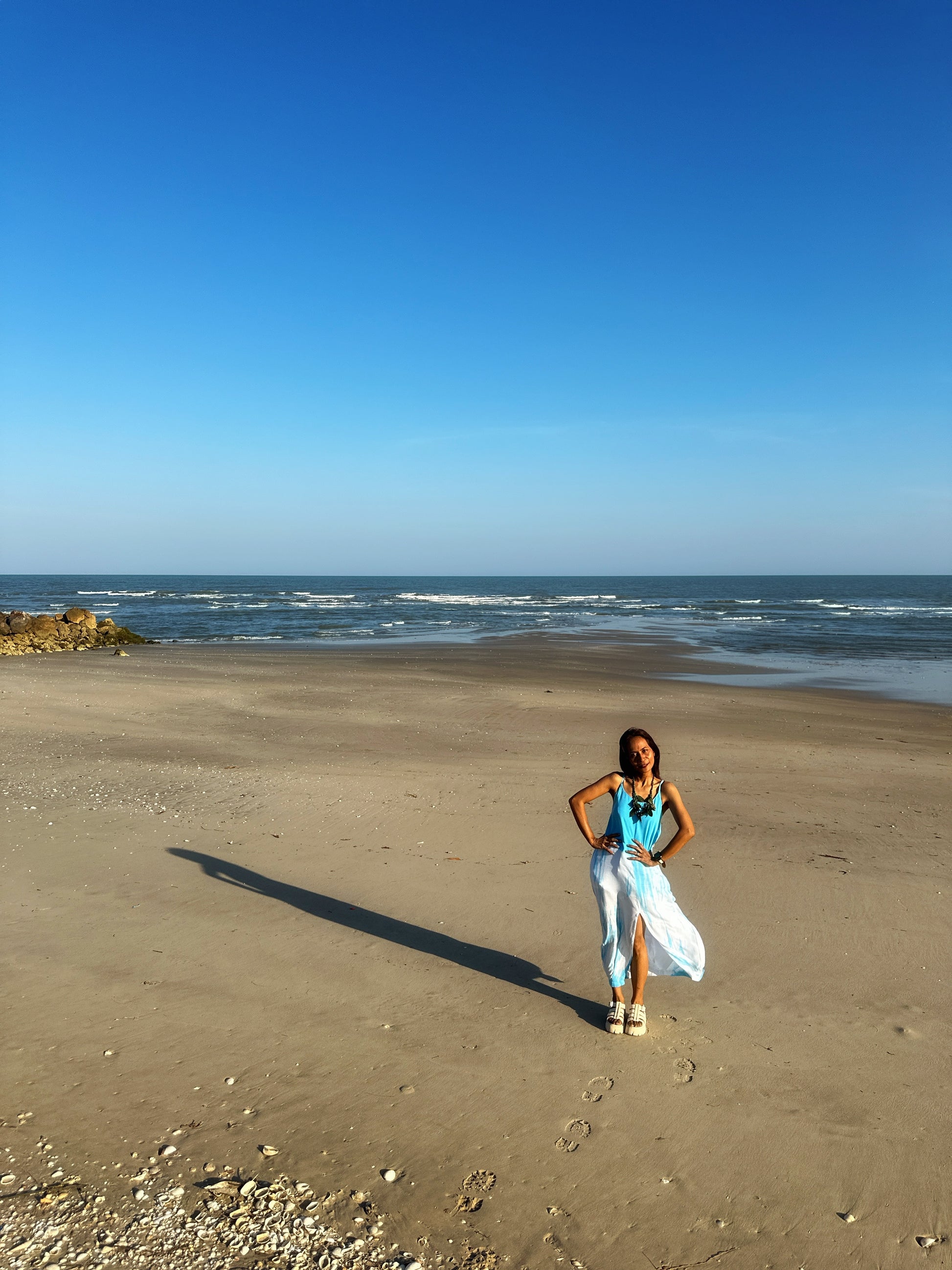 Elegant pose by model wearing a blue tie dye dress, highlighting the dress's comfort and flow. 