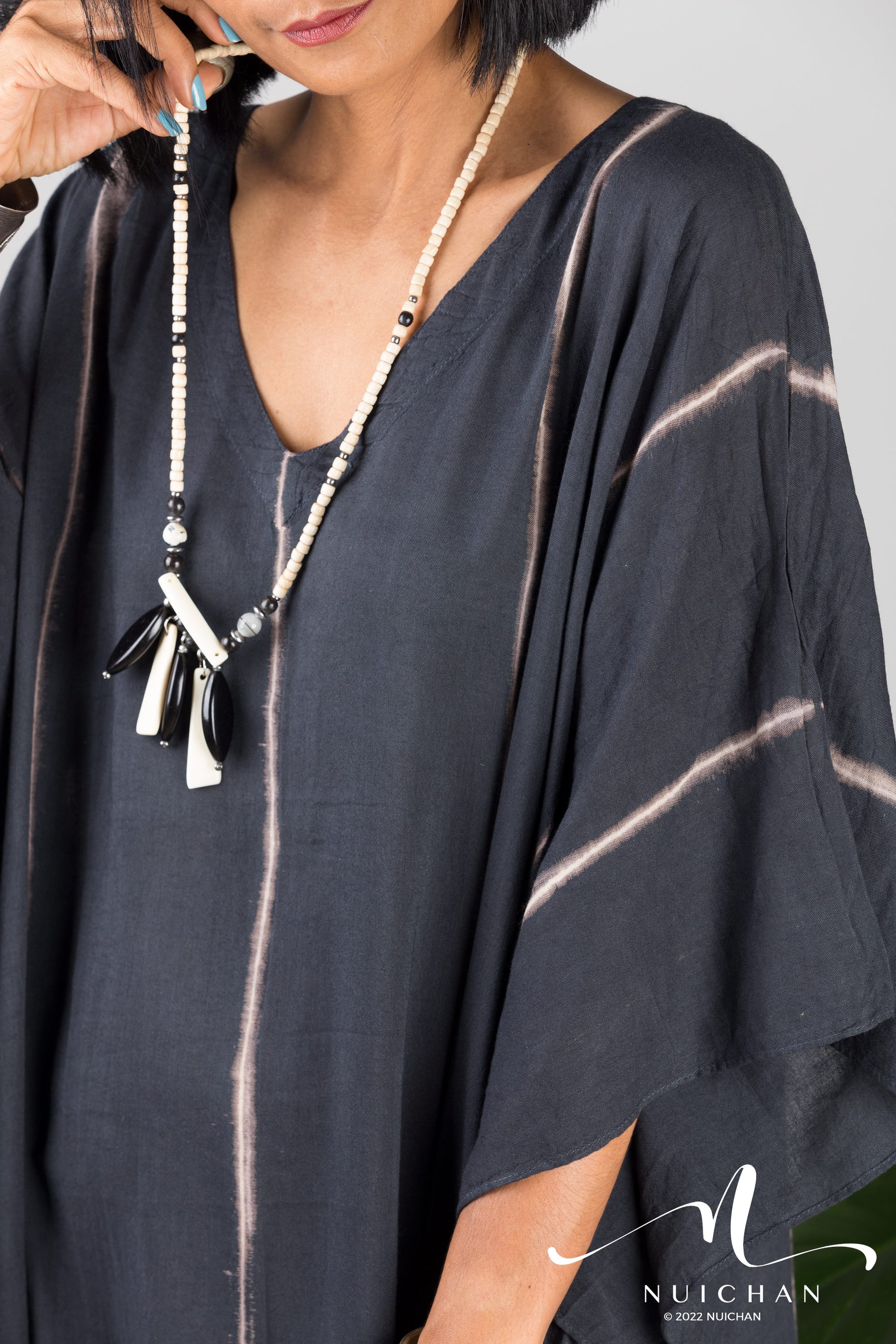 Nuichan Women Tie dye kaftan. Close up of a black tie dye dress with vertical stripes