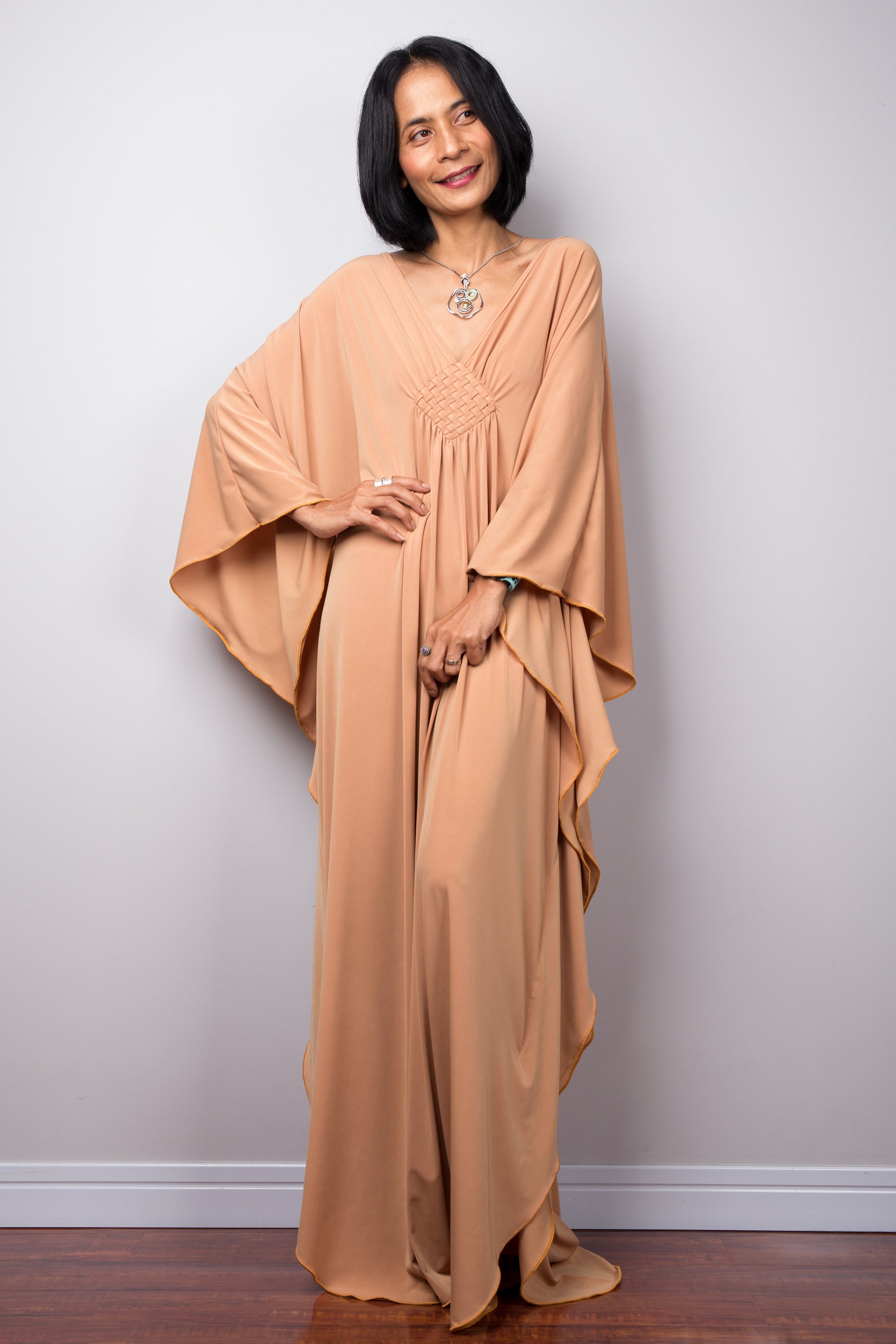 Long kaftan dress by Nuichan. V neck and woven detail on the chest.