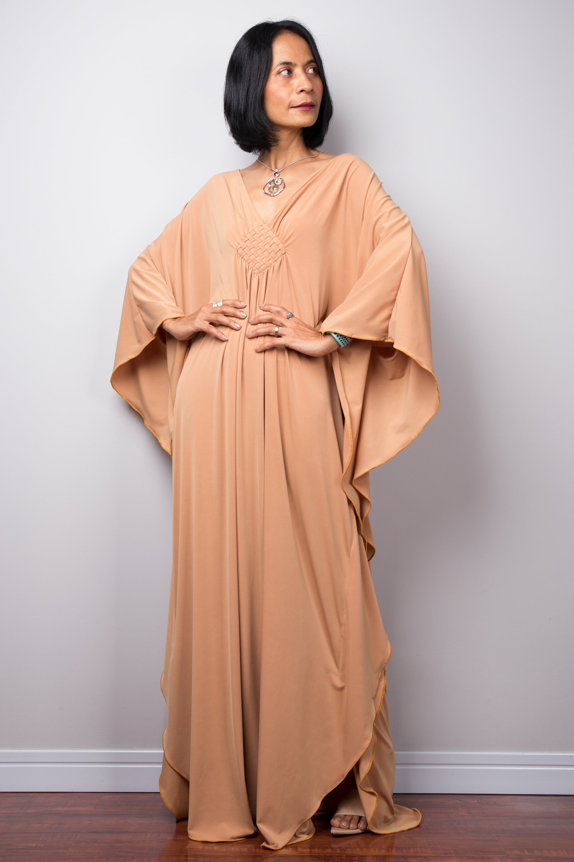 Long kaftan dress by Nuichan. V neck and woven detail on the chest.
Front view