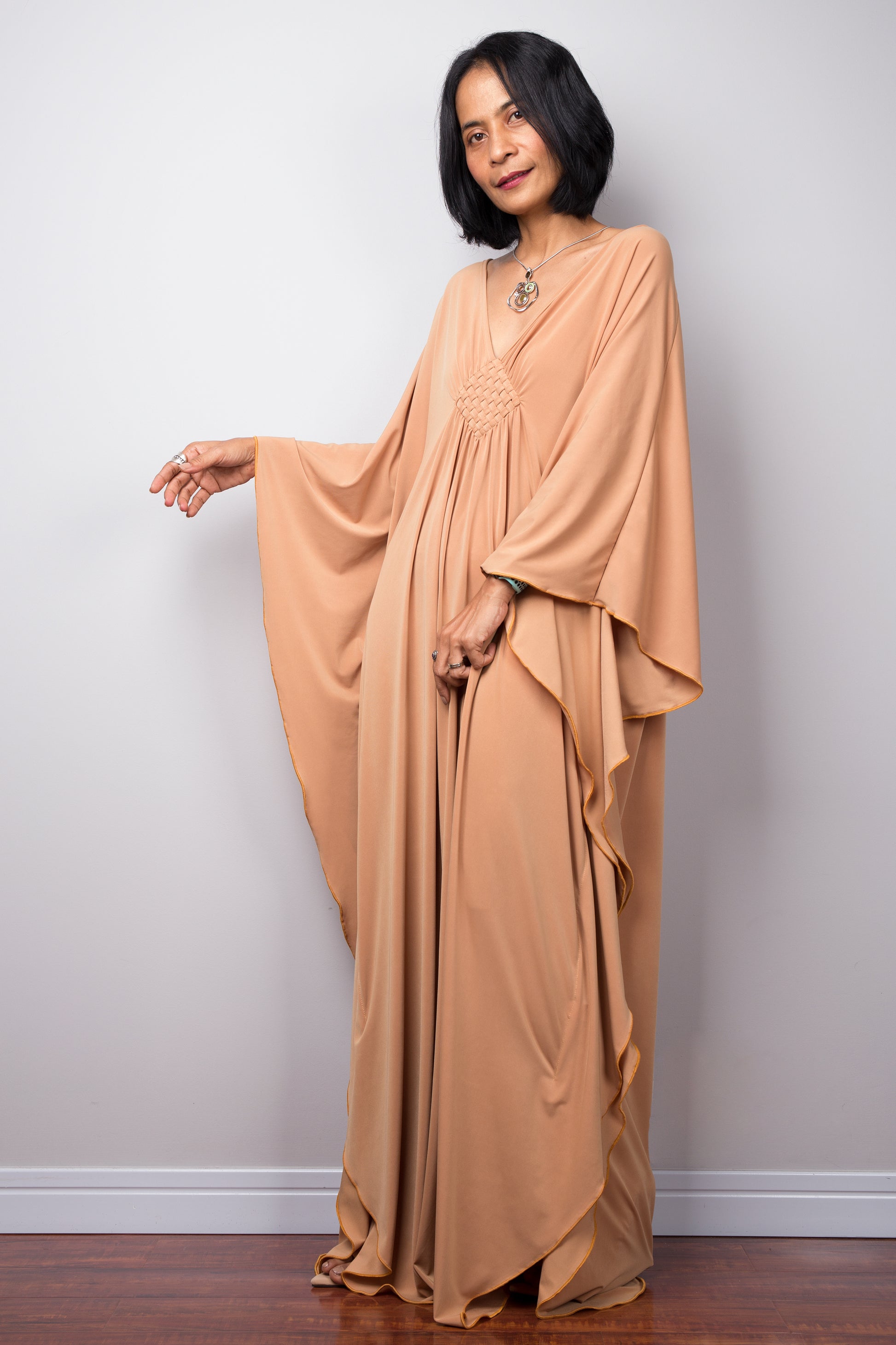 Long kaftan dress by Nuichan. V neck and woven detail on the chest. Side angle view
