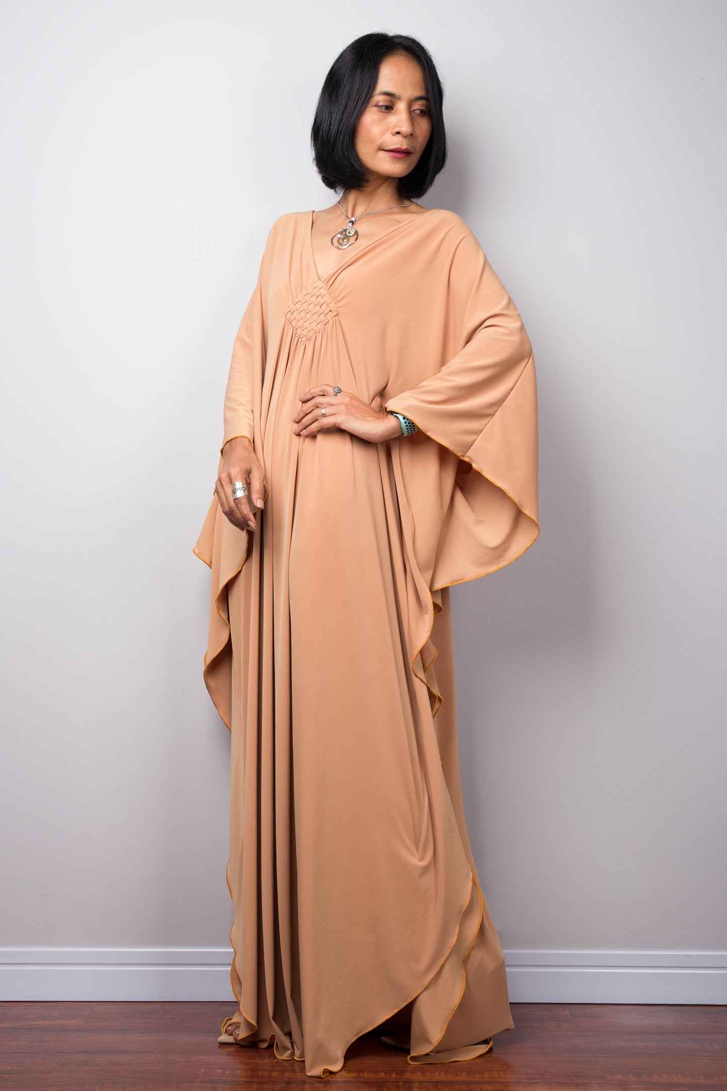 Long Champagne kaftan dress by Nuichan. V neck and woven detail on the chest.
