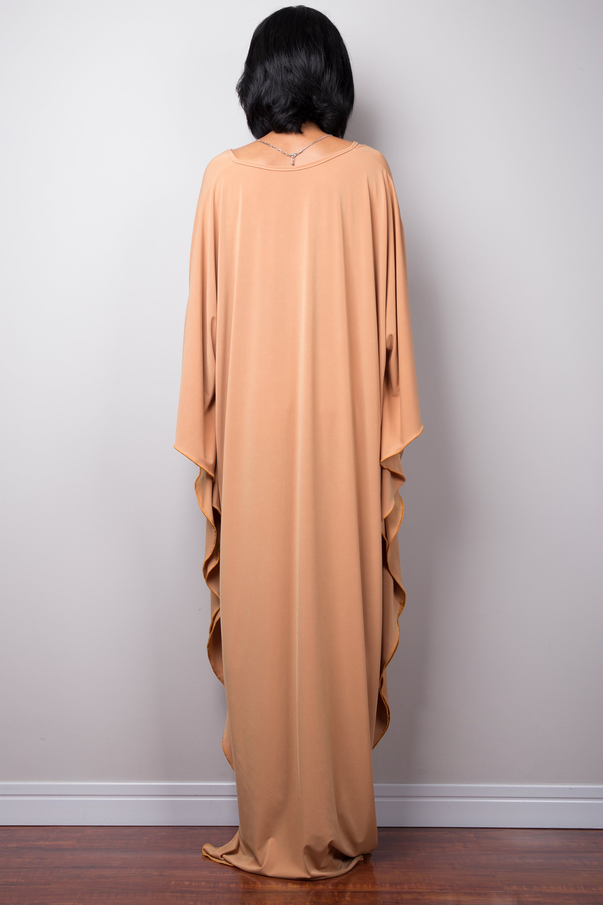 Long kaftan dress by Nuichan. V neck and woven detail on the chest.
Back view