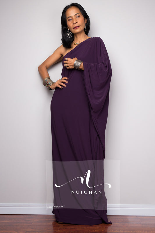 Elegant evening dress in rich purple with a one-shoulder design, showcasing a flowing silhouette and intricate detailing, perfect for special occasions.