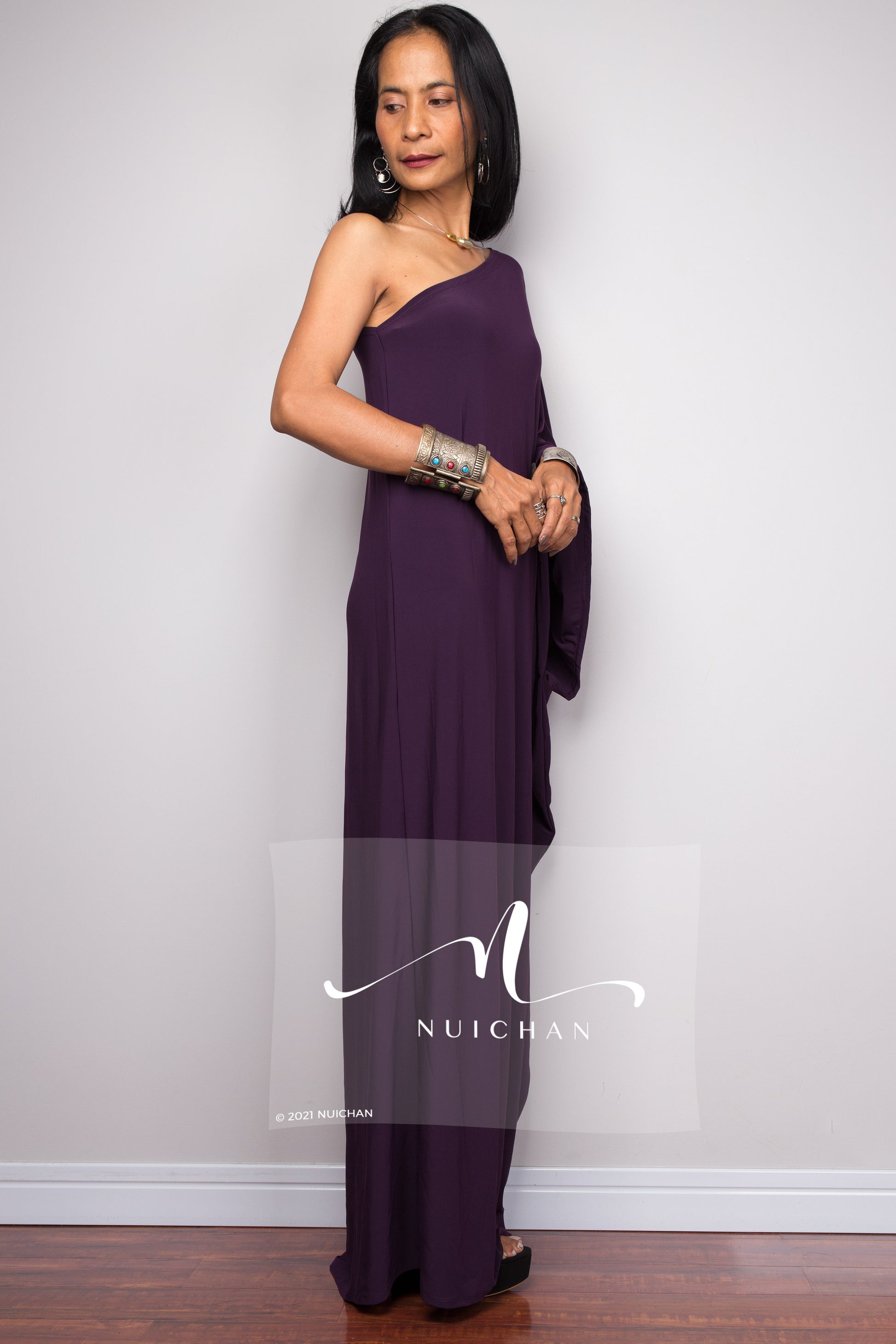 Regal purple evening dress with a one-shoulder design, showcasing a graceful shape. Side view.