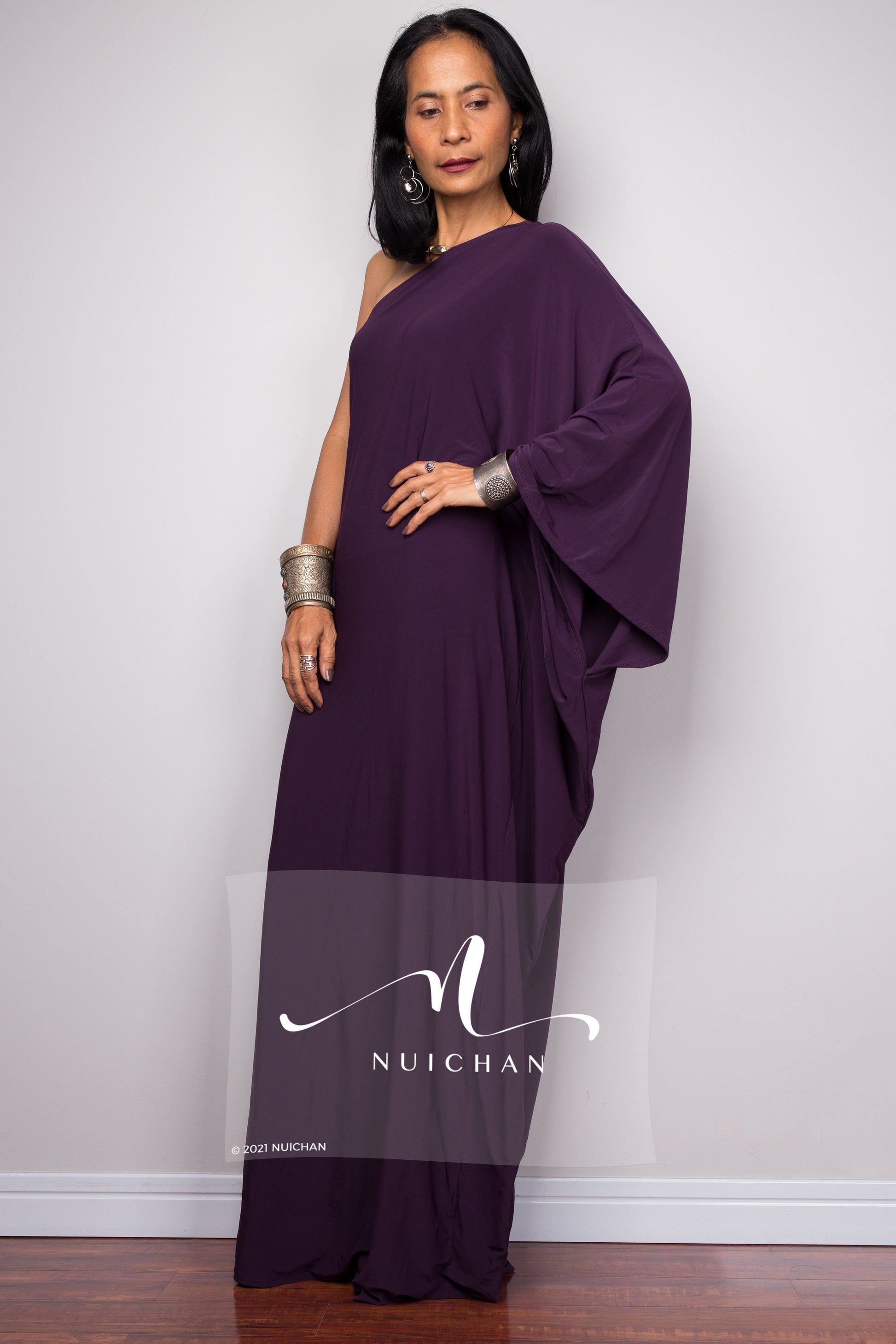 Striking purple one-shoulder evening dress featuring a flowing shape, ideal for special occasions