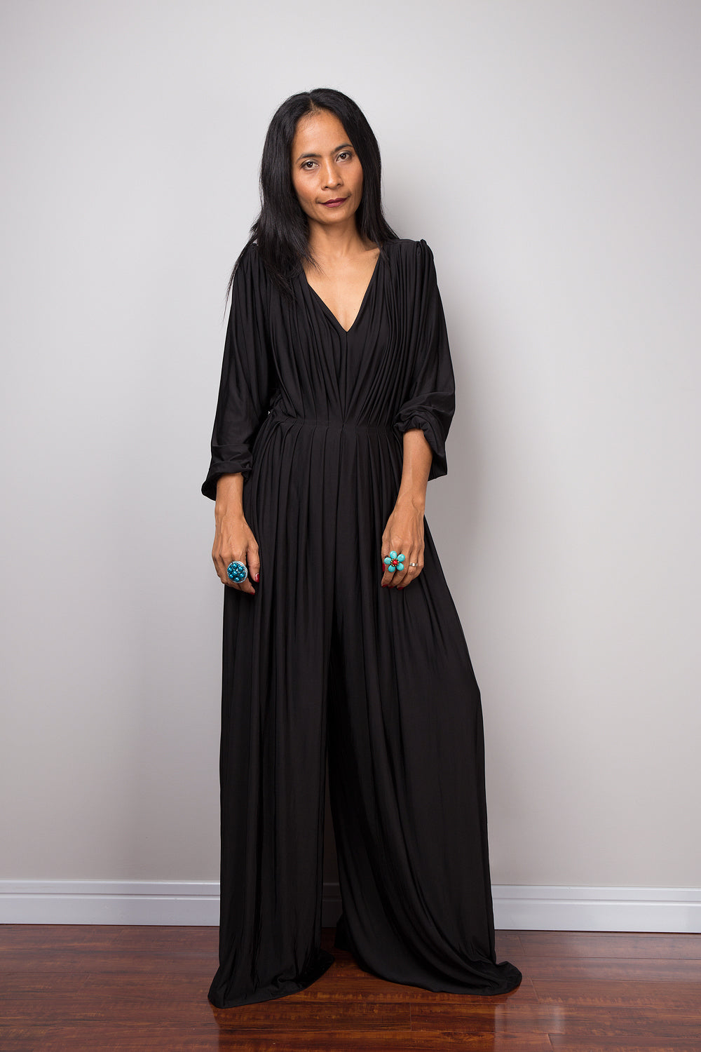 Black jumpsuit with high waist and plunging neckline.  Long sleeved pleated black jumper.