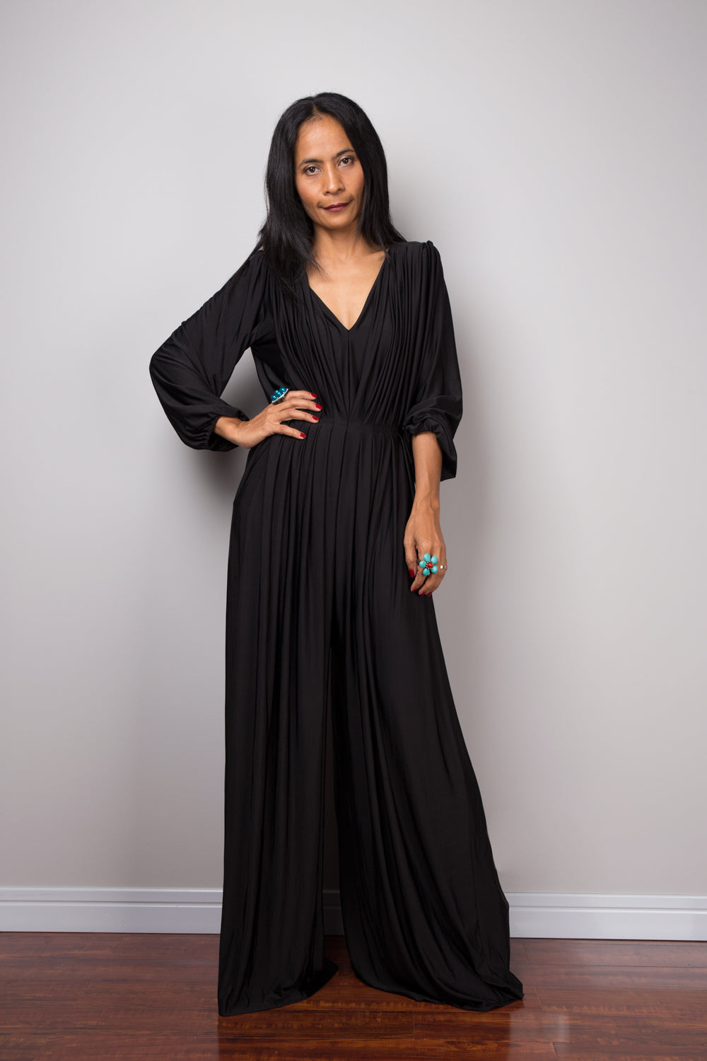 Black jumpsuit with high waist and plunging neckline.  Long sleeved pleated black jumper.