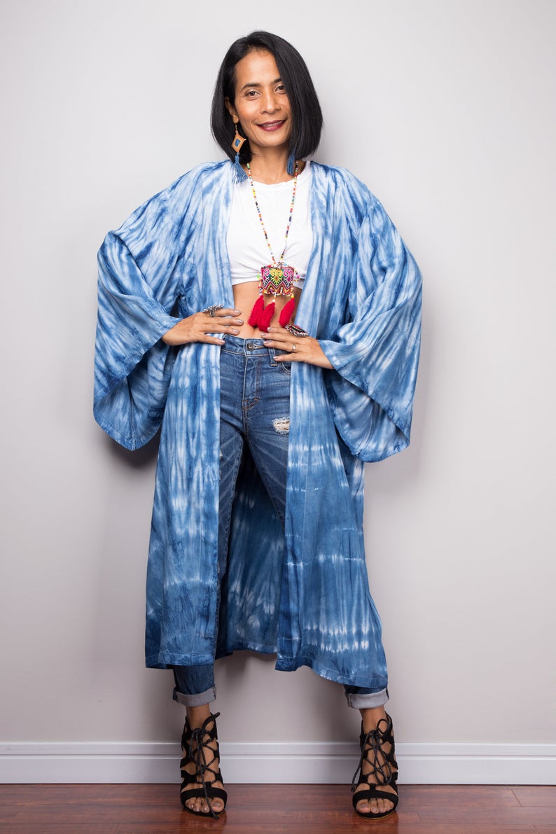 Woman wearing natural indigo shibori tie-dye open front cardigan with pockets. Hands on hips pose