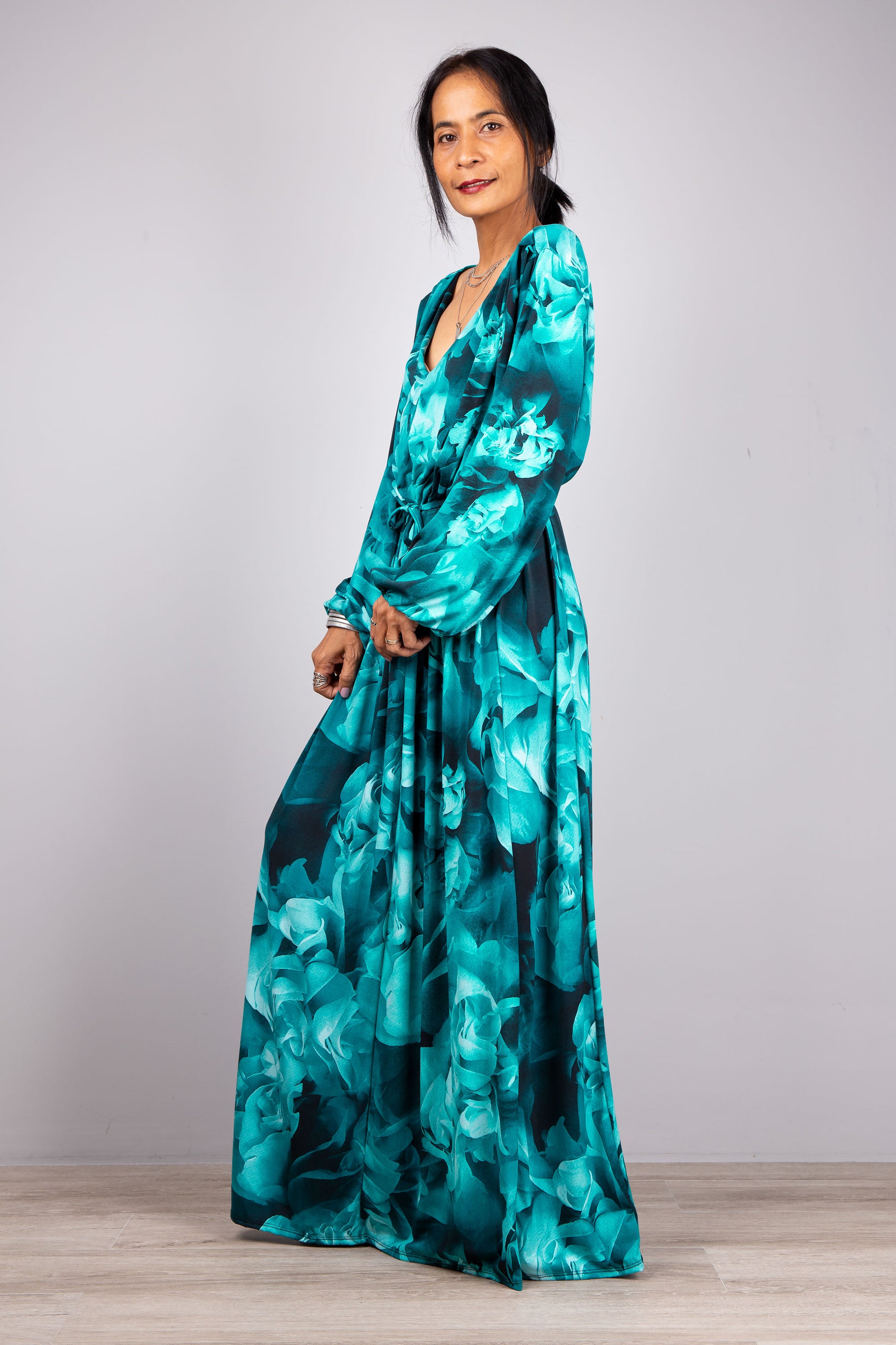 Flowing Grace: Watch our model in motion, the Boho Chic Maxi Dress in turquoise flowing seamlessly with every step against the backdrop of light grey.