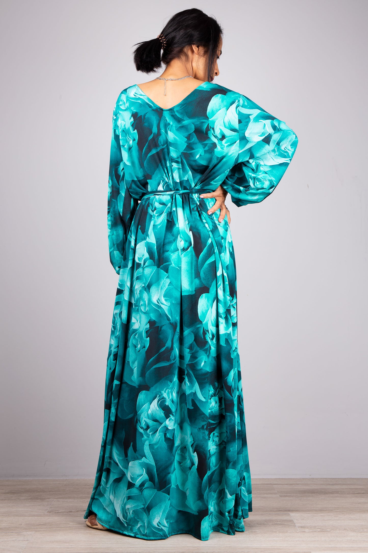 Boho Chic Unveiled: In this image, our model wears the Turquoise Boho Chic Maxi Dress, its design accentuated by the simplicity of the grey background.
